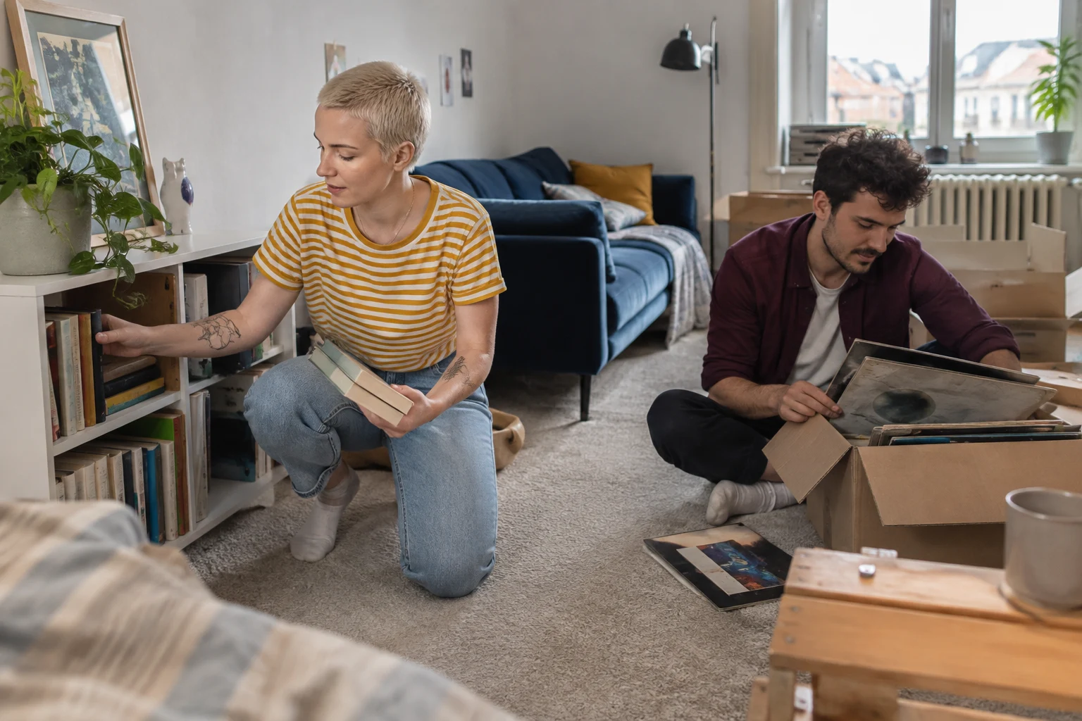 Ein Paar verteilt Bücher und persönliche Dinge in der gemeinsamen Wohnung.